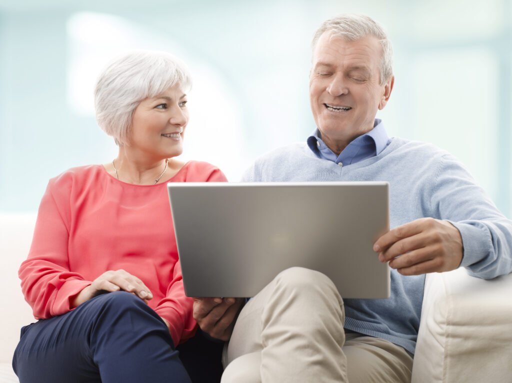 Casal sênior sorrindo fazendo compras online na Sênior Shop